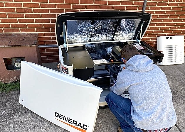 Generac Generator Generac generator installed on dirt next to brick building